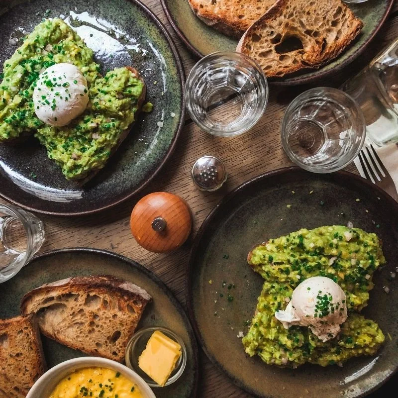 Varias tostadas saludables con aguacate y huevo poché